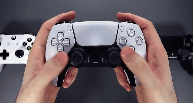 holding ps5 controller with ps4 controller in background